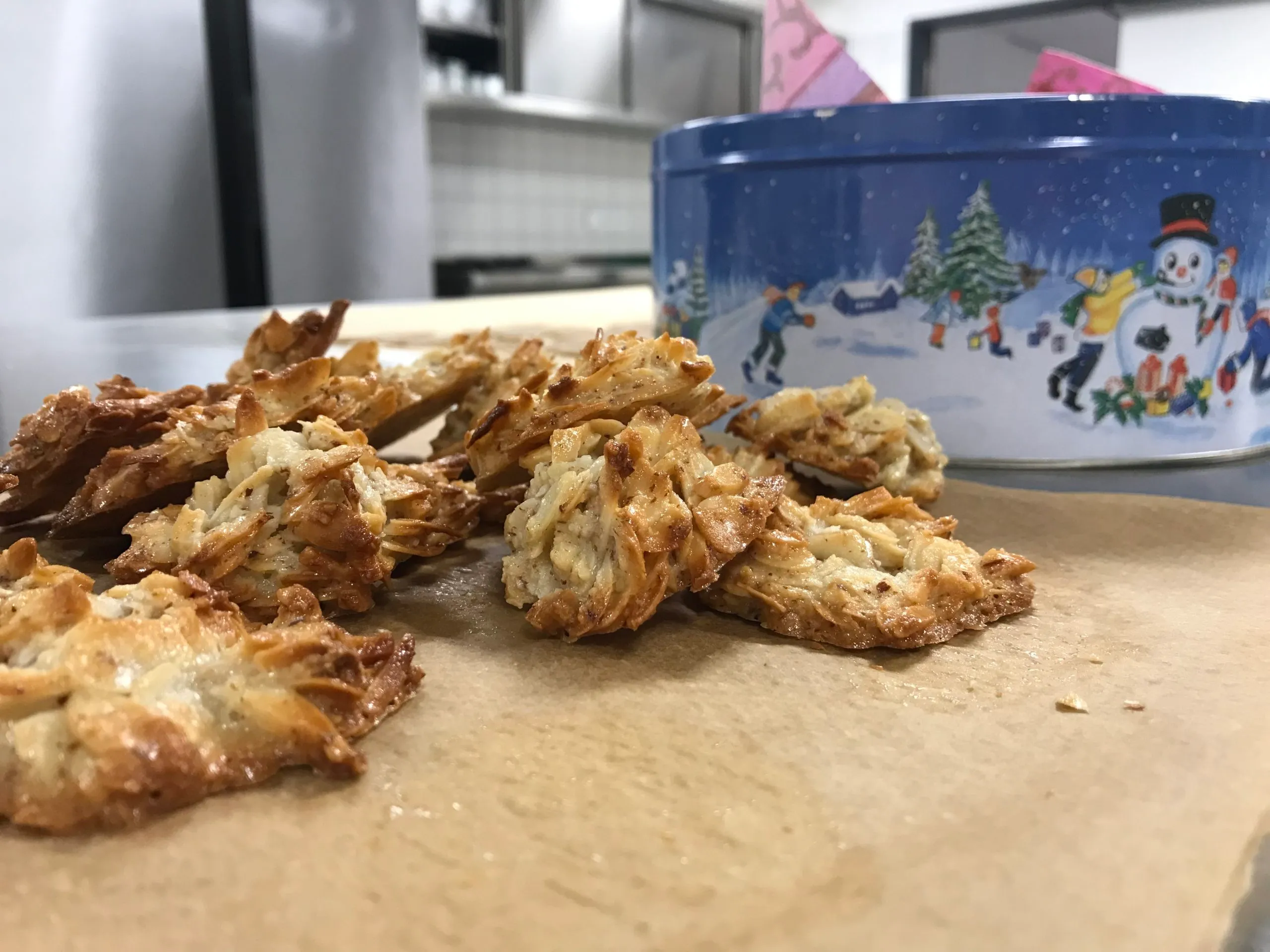 Mandelplätzchen, im Hintergrund eine Weihnachts-Plätzchendose